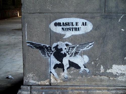 graffiti of dog with wings, by the words "Orasul e al nostru" (Romanian for "the city is ours")