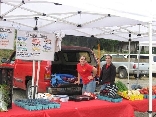 Cheri Fletcher (l.) and Lauren Michael, of Thompson Farms in Boring, Oregon, set up a stall at a local farmers market. Credit: Courtesy Thompson Farms and Boring Farmers Market