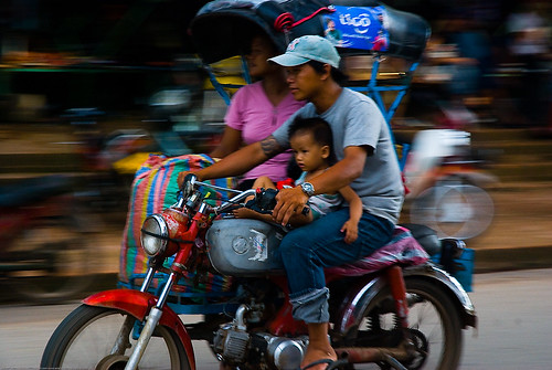 Family moving house on an auto-rickshaw in Luang Prabang, Laos