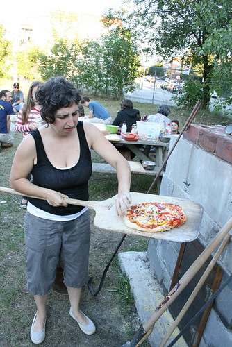 A volunteer checks a pizza before serving it to the hungry crowd at a public dinner last Saturday. 