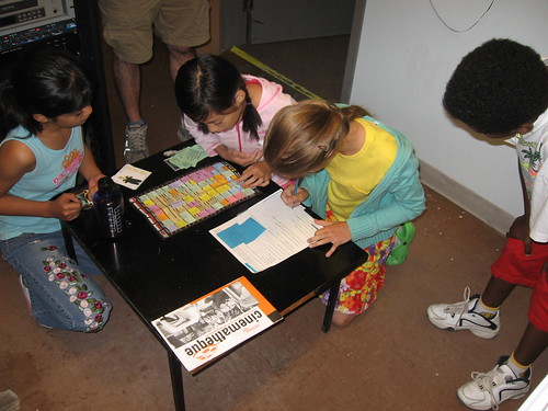 The kids pore over a copy of the CKUW Program Guide during a morning scavenger hunt.