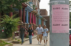 30912605Johns Hopkins students walk in Charles Village, near the Homewood campus. In the foreground is a post alerting residents and passers-by of a recent attack in the neighborhood.