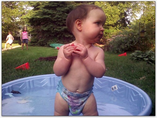 Talia standing up in the wading pool,  eating some watermelon (edited #2)