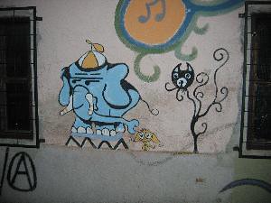 Slovenian graffiti of an elephant, a mouse, and cat's head growing on a stem