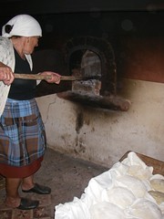 A avó a pôr os pães no forno