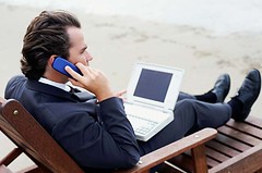 Werkverslaafd: laptop en mobieltje mee naar het strand