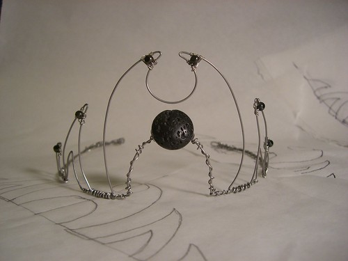 Completed tiara, formed by bending stainless steel wire and wiring glass and lava beads to it.