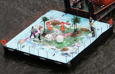 Giant monopoly game pulled by a barge