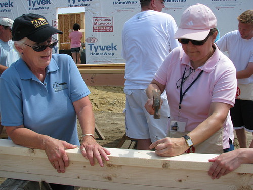 Peggy Gallego, Milford Housing Development Corporation and USDA Housing Administrator Tammye Trevino (Right) take turns at building walls for Suzanne and Dennis Passwaters new home.