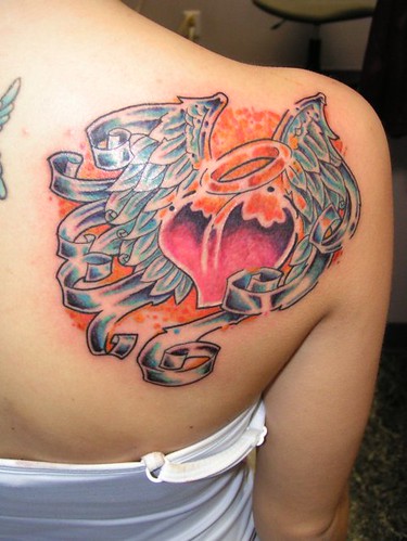 Color tattoo of an angel heart with feathered wings and a halo
