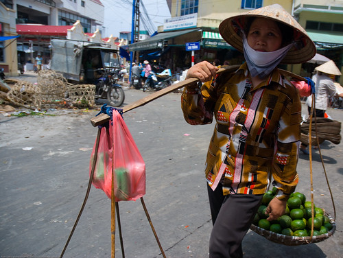 Woman carrying a yoke in Hanoi, Vietnam
