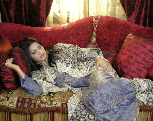 Actress Reem Abdullah reclining on a sofa