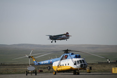 Kyzyl airport. Mi-8 on parking with An-2 landing on background ©  Pavel 