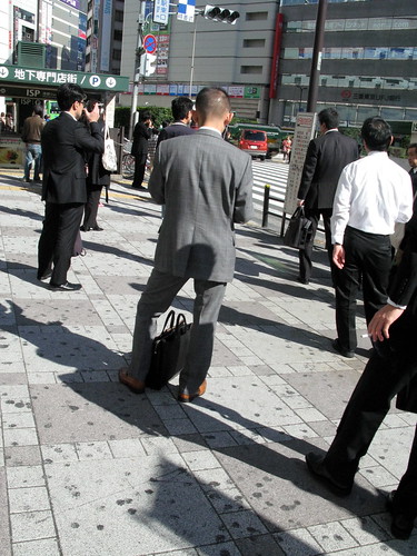 日本不能邊走邊抽煙，所以一群上班族都停著抽煙