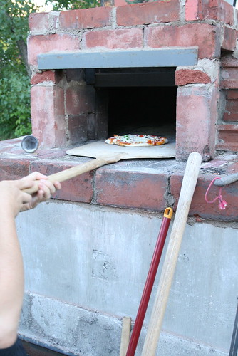 A pizza comes out of the oven, ready for the eatin'.