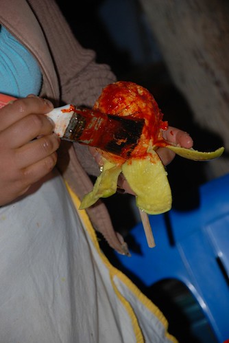 covering a mango with chile sauce