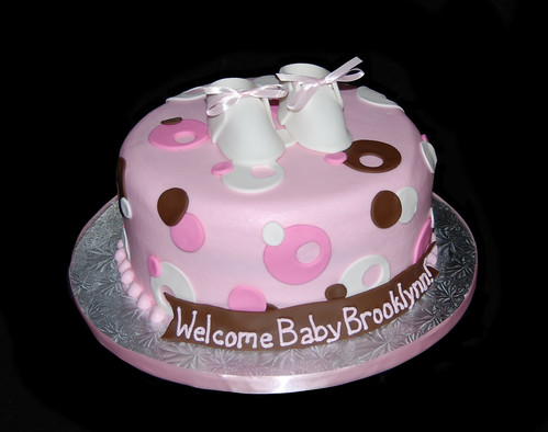 pink white and brown sassy circles baby shower cake with booties