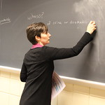 A professor writing on a chalkboard