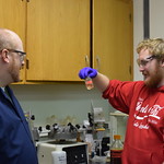 A student conversing with his professor during a lab experiment.