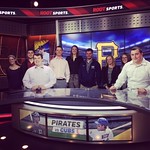 Students pose for a photo behind a news desk at ROOT Sports