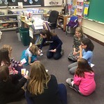 Students helping elementary students in a classroom