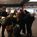 Students posing together in an airport.