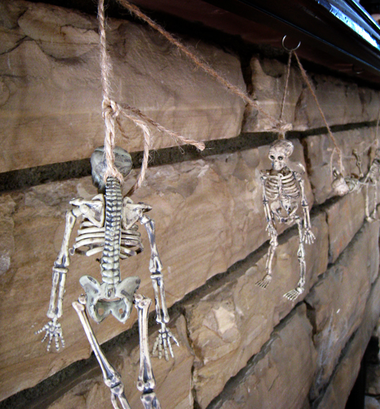 little skeletons hanging from the mantel+halloween decorations