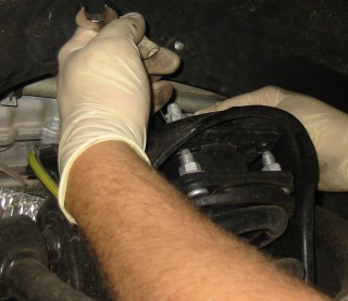 Removing four top bolts from coil-over/strut assembly.