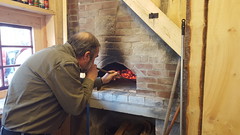 John stoking the pizza oven fire