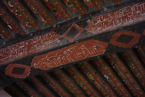 Au plafond, des poutres décorées avec des inscriptions en arabe
